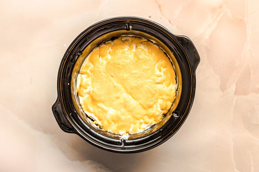 Crockpot John Wayne Casserole Cheese Layered On Top of Sour Cream Mixture in a Crockpot