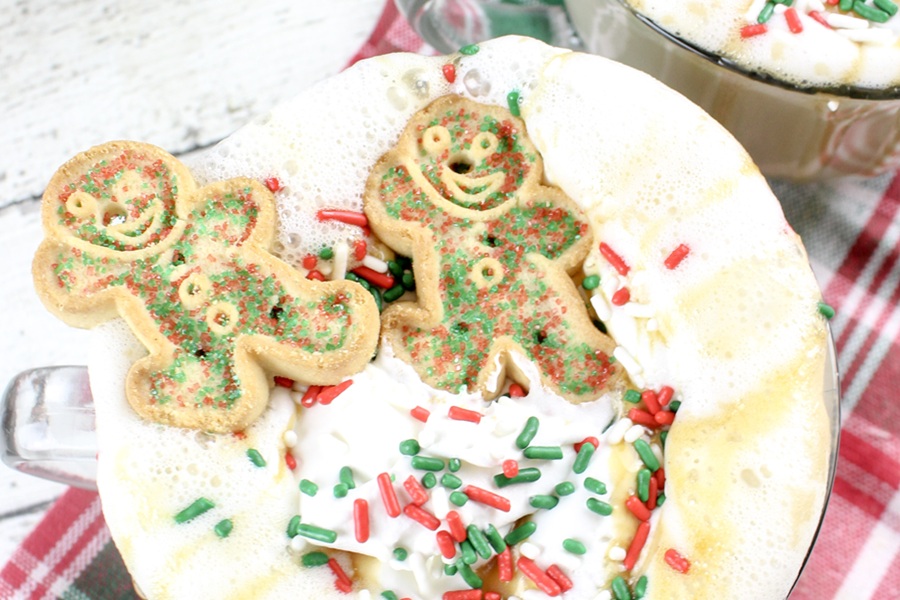 Festive Christmas Latte Recipe Clsoe Up of Whipped Garnish with Two Gingerbread Cookies and Sprinkles