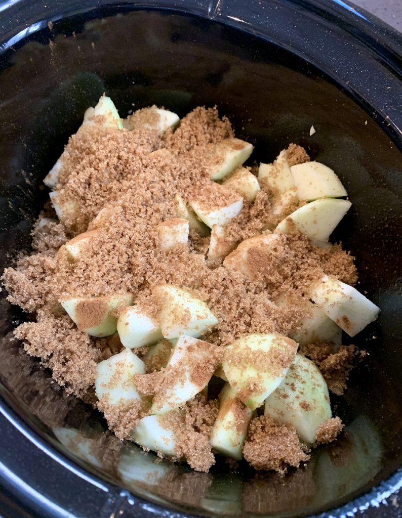 Crockpot Apple Crisp Apples in Crockpot Covered in Cinnaomn and Brown Sugar