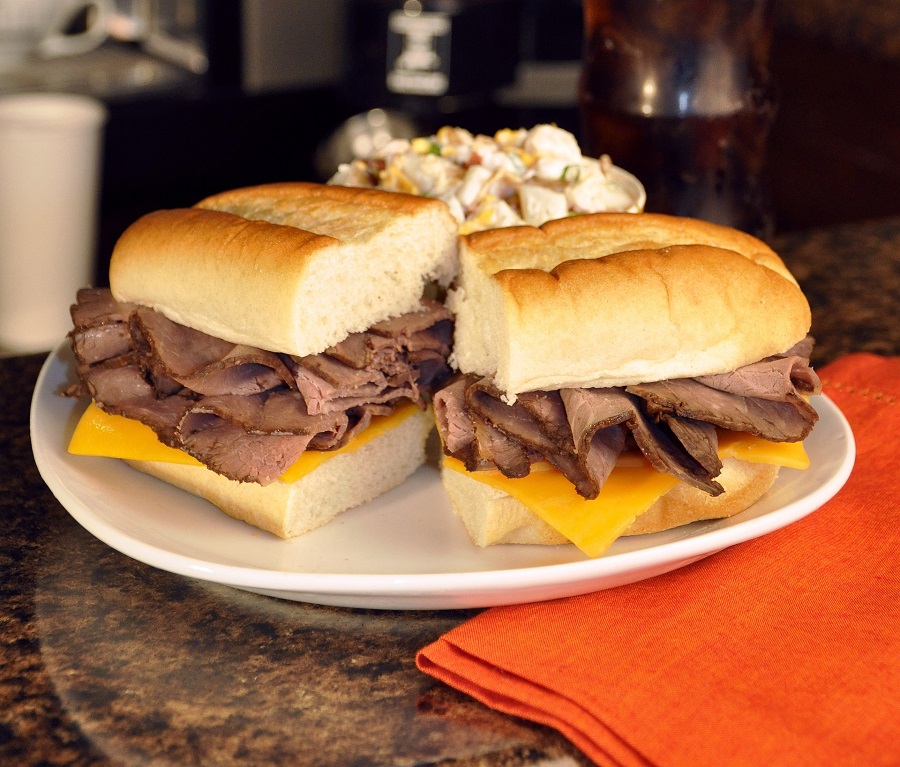 Crockpot Beef Sandwich Recipes A beef Sandwich on a Plate Cut in Half and Split Open