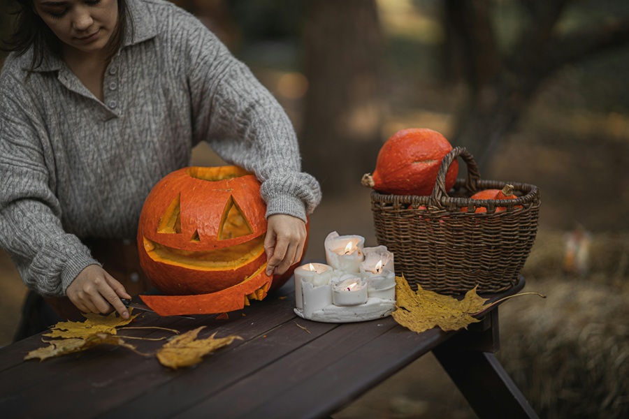 Halloween Pasta Recipes a Person Carving a Pumpkin on a Wooden Table Outside