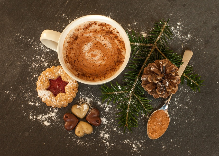 Hot Cocoa Crockpot Recipes Overhead View of a Cup of Hot Chocolate Surrounded with Cookies, Pine Tree Branches, and Pinecones