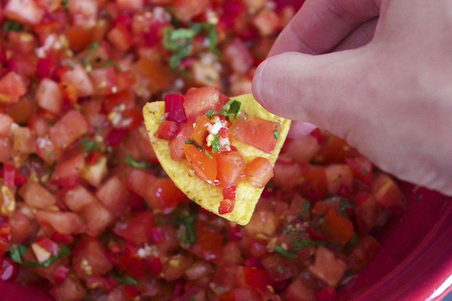 Crockpot Salsa Recipes Person Holding a Chip Above Salsa with Salsa on the Chip