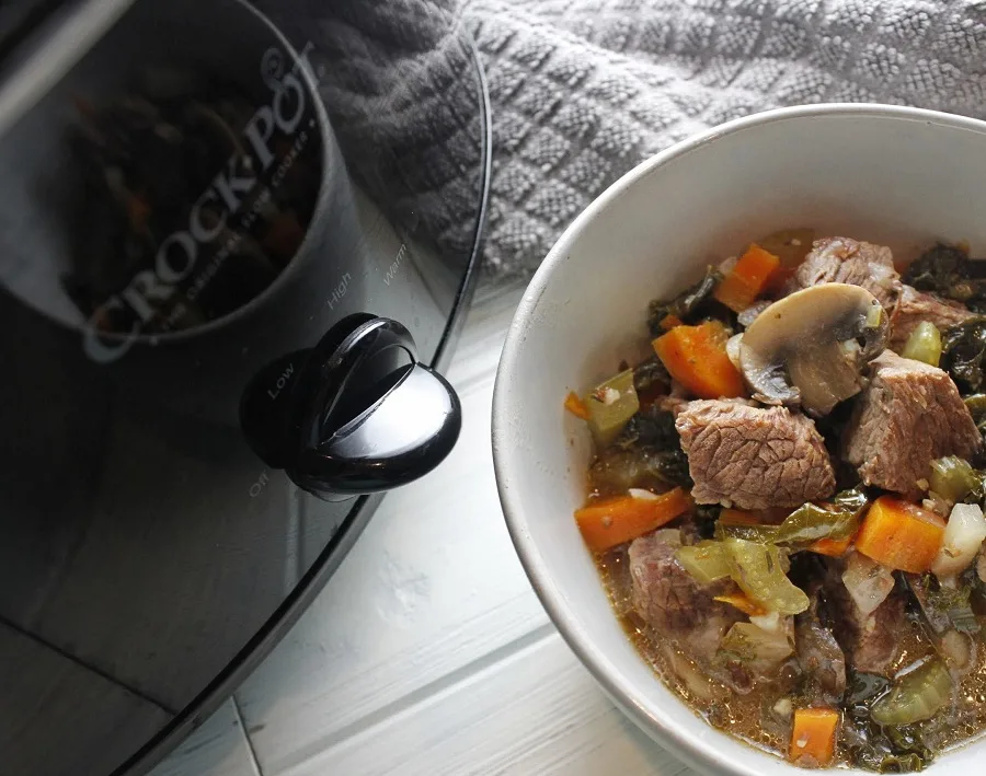 Healthy Slow Cooker Beef Stew Bowl of Stew Next to a Crockpot