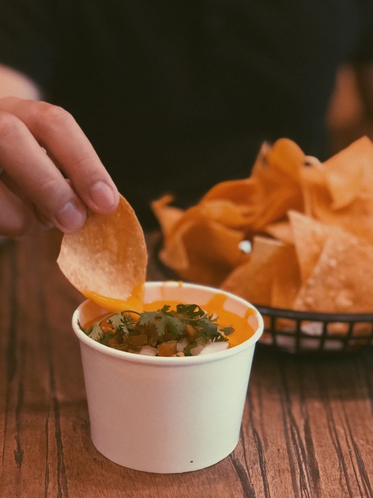 Crockpot Cheese Dip Recipes Person Dipping a Chip into a Cup of Dip