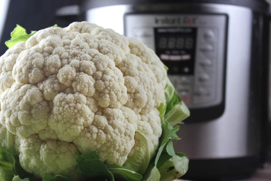 Instant Pot Cauliflower Mash Recipe Close Up of a Head of Cauliflower in Front of an Instant Pot
