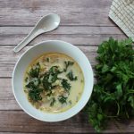 Easy Creamy Kale Soup Overhead View of a Bowl of Kale Soup with a Soup Spoon and a bundle of Parsley