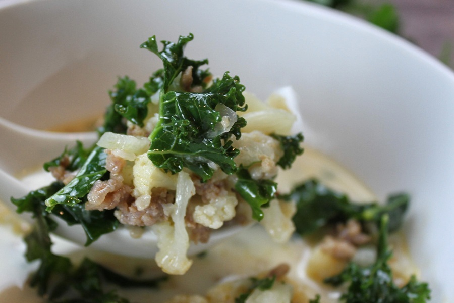 Easy Creamy Kale Soup Close Up of a Spoonful of Kale Soup Being Held Just Above a Bowl of Kale Soup