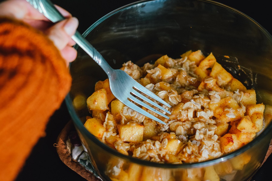 Crockpot Desserts for a Crowd Woman Eating Cobbler From a Bowl