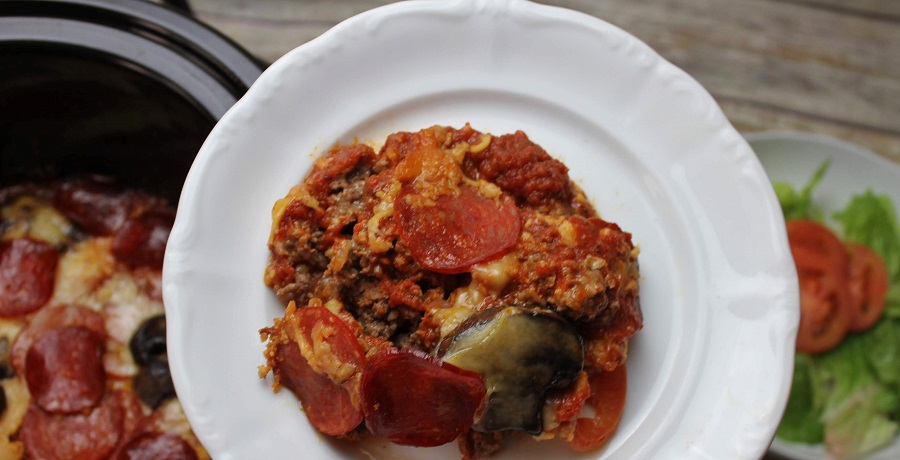 Crockpot Pizza Recipes Casserole on a Plate Held Above a Crockpot