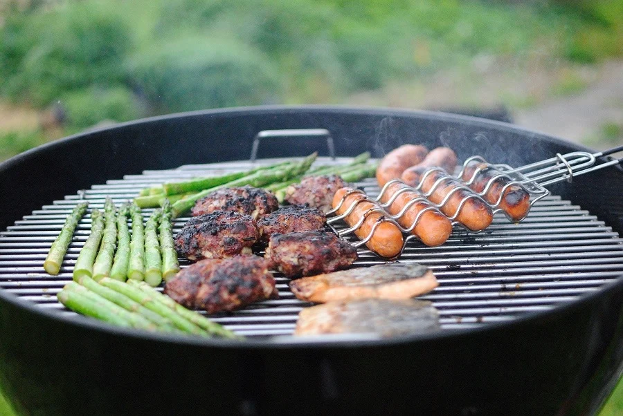 Instant Pot Outdoor BBQ Recipes Hot Dogs, Burgers, and Asparagus Grilling on a Round BBQ Pit