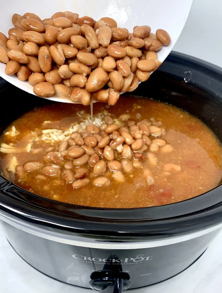 Crockpot Chicken and Rice Burrito Bowl Recipe Person Pouring Beans into Crockpot