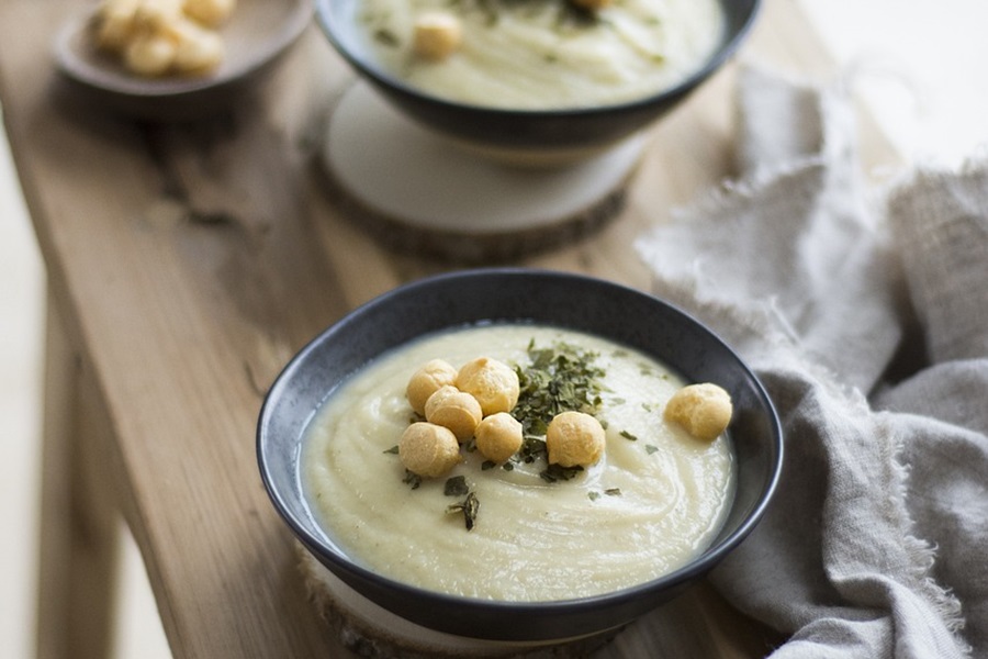 Instant Pot Recipes with Cauliflower Two Black Bowls Filled with Cauliflower Soup on a Wooden Table