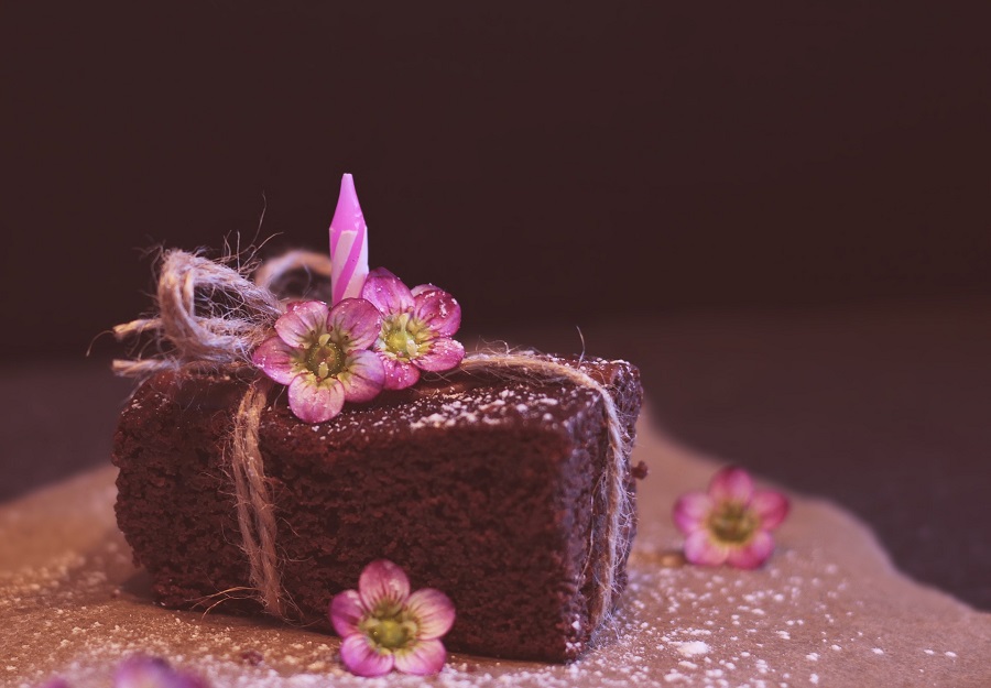 Instant Pot Brownie Desserts A Single Brownie with a Candle in it and Flowers On Top