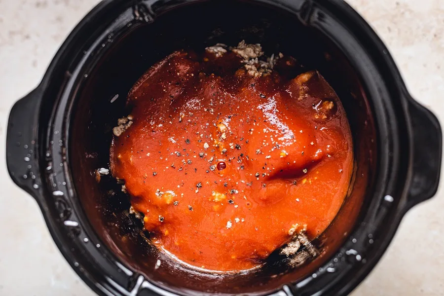 Unstuffed Cabbage Rolls Slow Cooker Recipe Inside View of a Crockpot with the Tomato Mixture Layered ontop