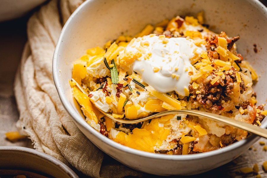 John Wayne Casserole with Tater Tots Recipes Close Up of a Bowl of Casserole with a Dollop of Sour Cream