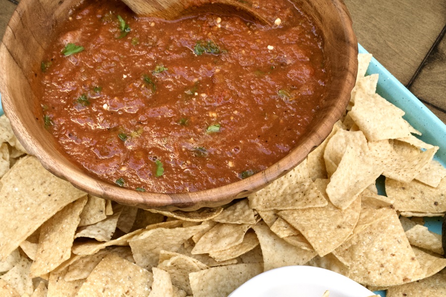 Homemade Slow Cooker Salsa a Wooden Bowl of Salsa with Tortilla Chips All Around It