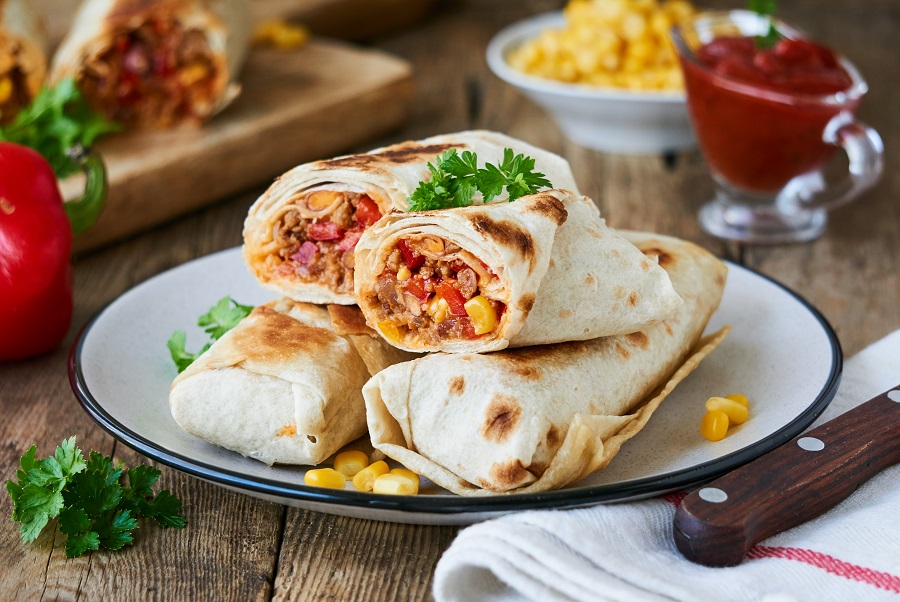 Instant Pot Breakfast Burrito Four Burritos Sitting on a Plate with Ingredients in the Background