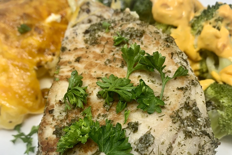 Instant Pot Frozen Pork Chops Close Up of a Pork Chop with Parsley and Side Dishes