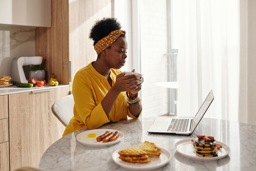 Easy Instant Pot Breakfast Recipes a Woman Sitting at a Table with a Laptop in Front of Her and a Plate of Breakfast Next to the Laptop