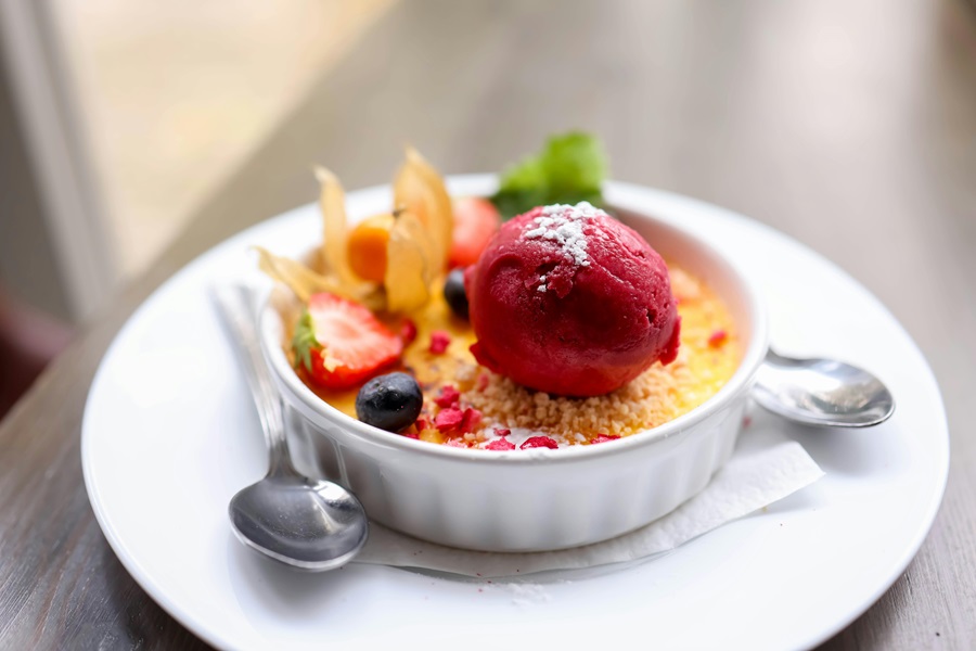 Easy Instant Pot Desserts for a Crowd a Creme Brulee Topped with Sherbet Ice Cream and a Sprig of Mint