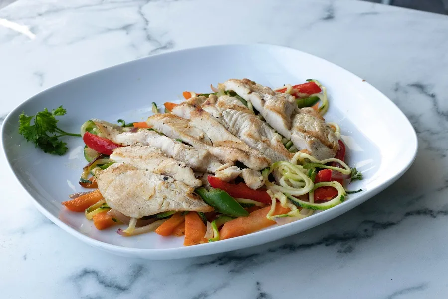 How to Cook Instant Pot Chicken Sliced Chicken on a White Plate with Roasted Veggies