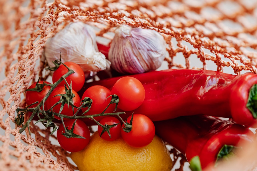 Instant Pot White Chicken Chili Recipes Overhead View of a Red Net Bag Filled with Garlic, Peppers, and Tomatoes