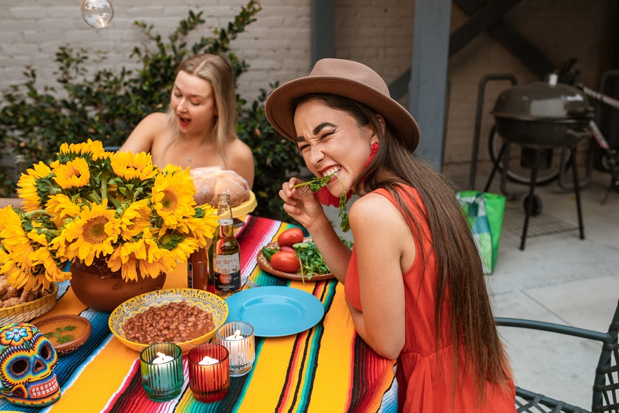 Instant Pot Cinco de Mayo Recipes a Woman at a Cinco de Mayo Party Eating a Pepper