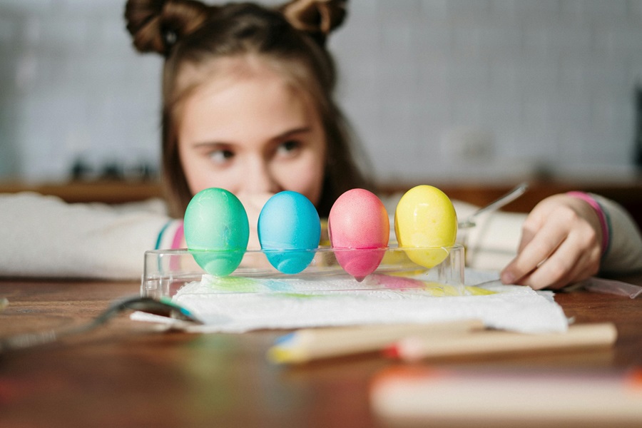 Delicious and Easy Crockpot Easter Recipes a Young Girl Looking at a Row of Painted Eggs Sitting on a Kitchen Table