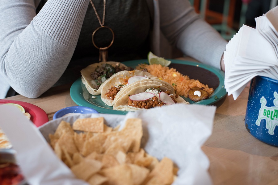 Instant Pot Cinco de Mayo Recipes Close Up of a Table with Mexican Food on it and a Woman Sitting at the Table