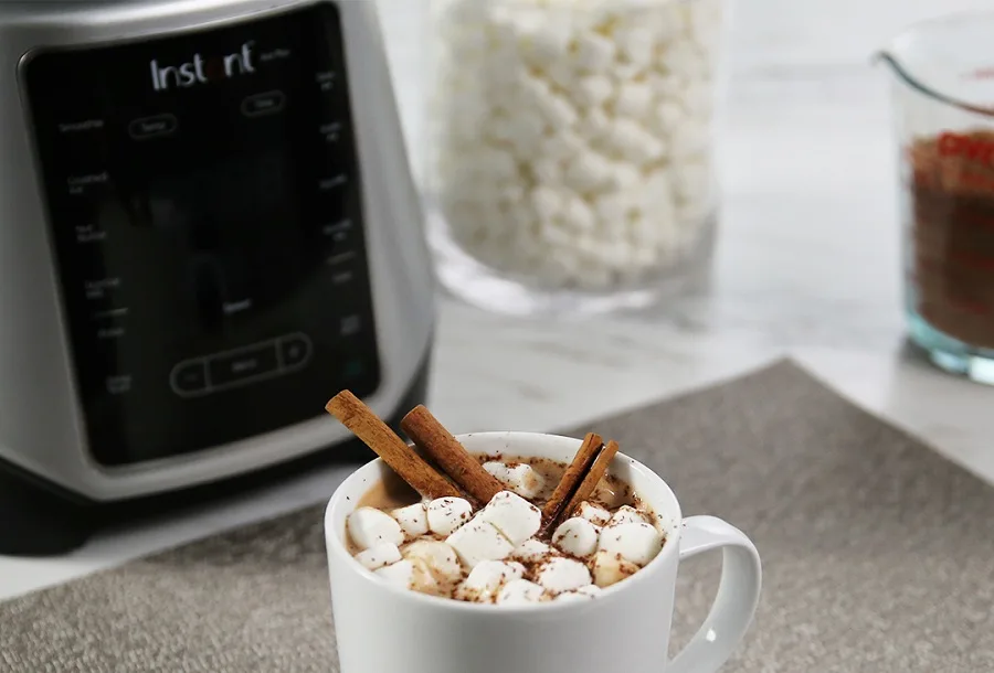 Instant Pot Ace Blender Tips and Tricks A Cup of Hot Chocolate with Marshmallows and Cinnamon Sticks in Front of a Blender