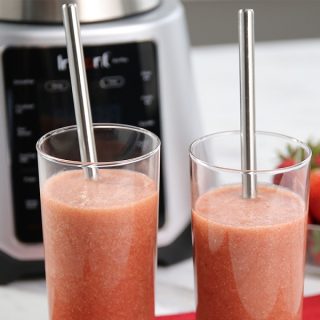 Instant Pot Ace Blender Tips and Tricks Two Glasses Filled with Smoothie in Front of an Ace Blender and a Small Bowl of Strawberries