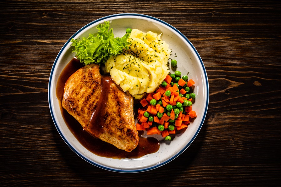 Instant Pot Chicken and Gravy Recipes Roast chicken breast with mashed potatoes, carrot and green peas on wooden background