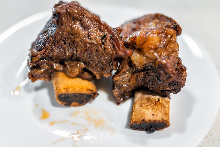 Slow Cooker Short Ribs Recipes Close Up of Two Short Ribs on a White Plate