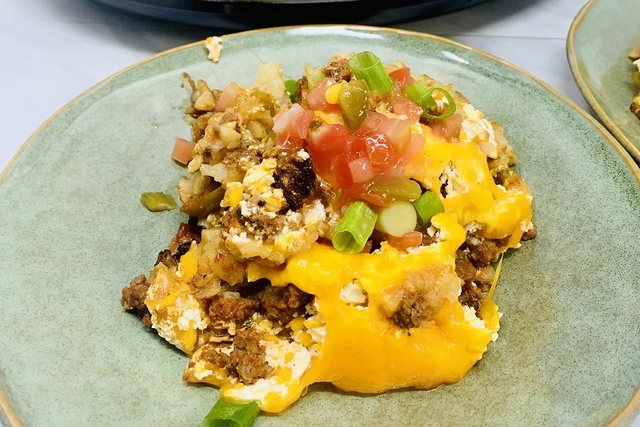 Crockpot Dump Dinners John Wayne Casserole on a Plate Sitting in Front of a Crockpot