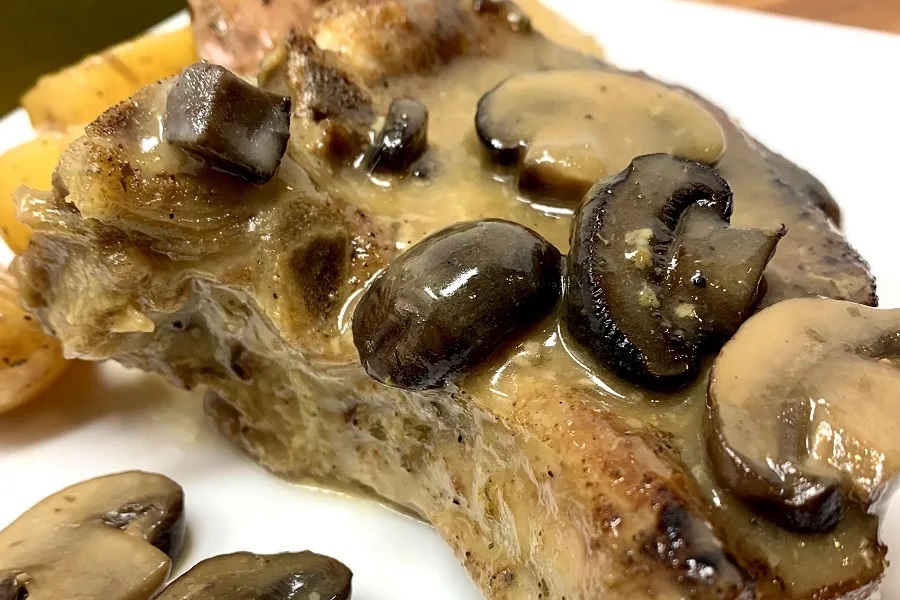 Crockpot Dump Dinners Close Up of a Pork Chop Covered in Mushroom Sauce