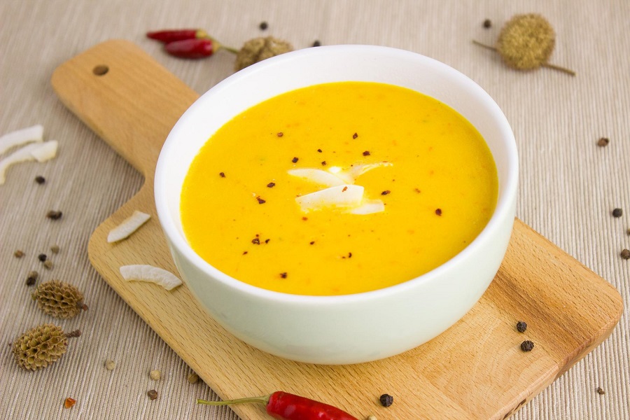 Instant Pot Blender Soup Recipes Close Up of a Bowl of Yellow Soup on a Wooden Cutting Board