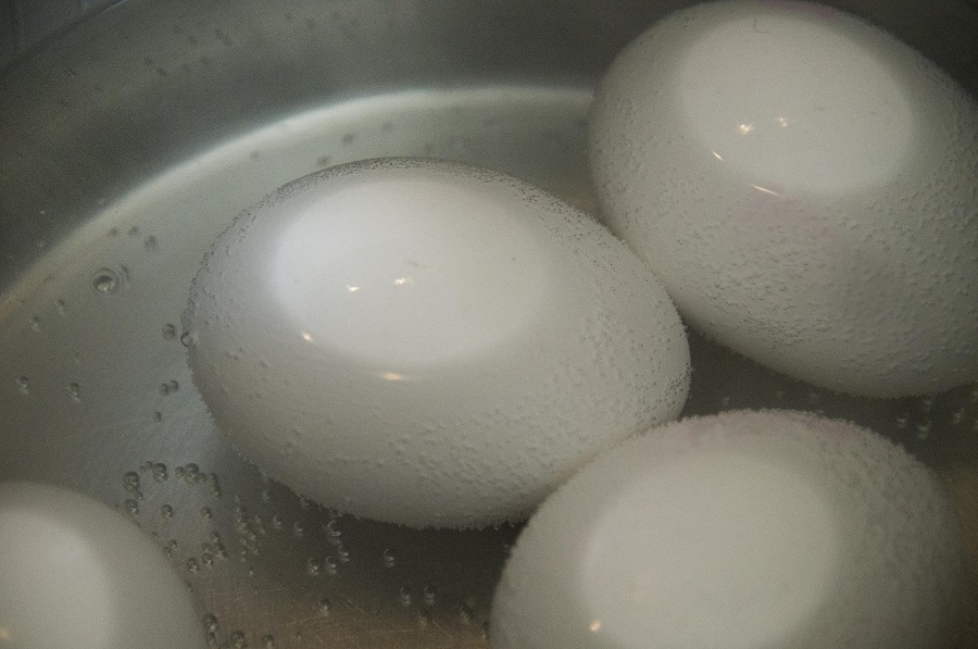 How to Make Instant Pot Hard Boiled Eggs Close Up of Three White Eggs in a Pot of Water