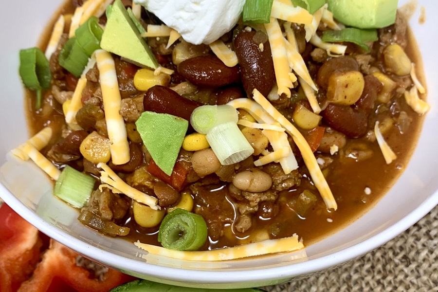 How to Make Instant Pot Chili Close Up of a Bowl of Chili with Cheese, Avocado, and Sour Cream
