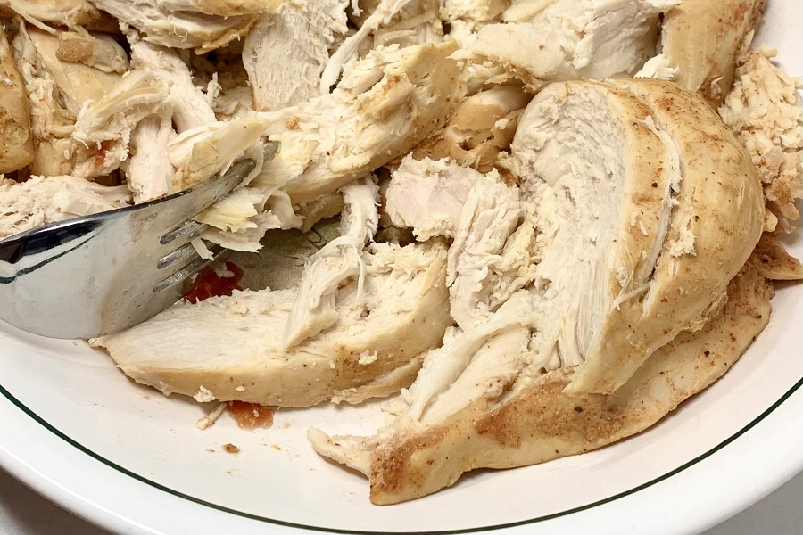 How to Make Instant Pot Shredded Chicken Close Up of a Plate of Chicken Being Shredded