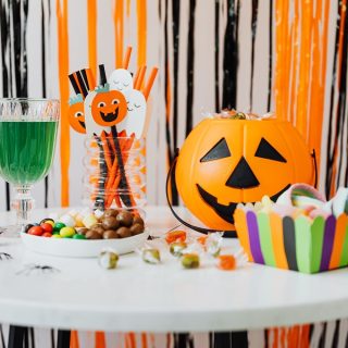 Instant Pot Halloween Party Recipes Halloween Decor on a Table with Streamers Hanging Behind Them