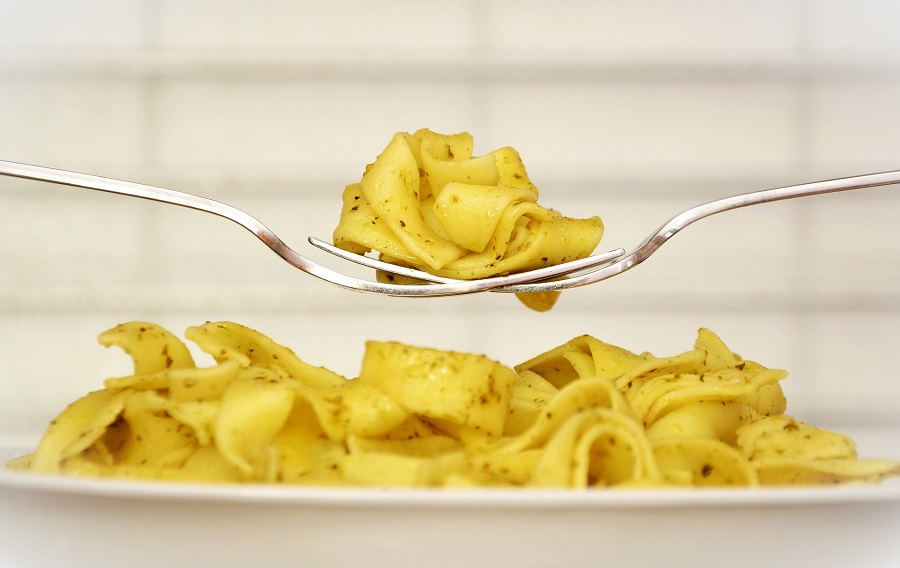 Instant Pot Chicken Pasta Recipes Close Up of Two Forks with Pasta Hovering Above a Plate of Pasta