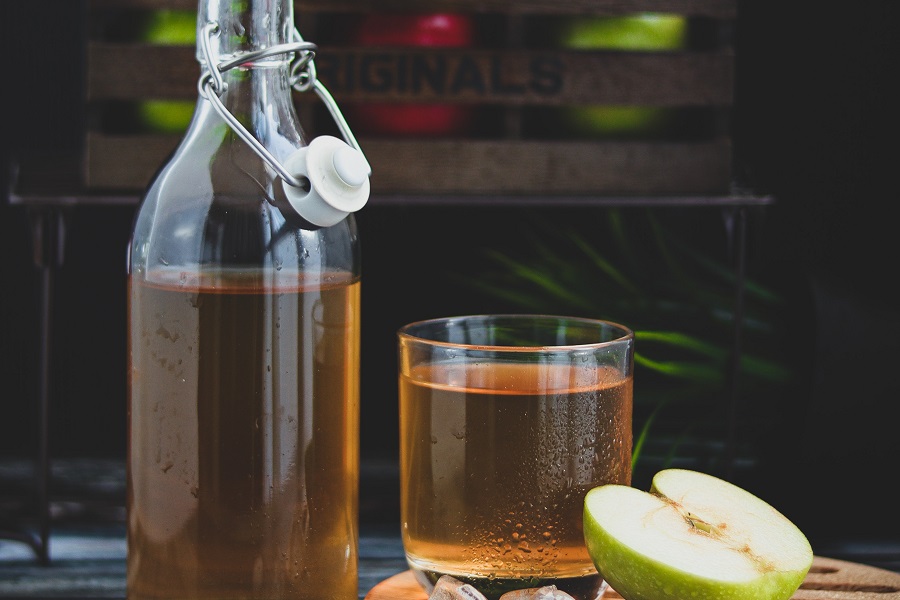 Crockpot Bourbon Punch Recipes Close Up of a Bottle of Apple Cider Next to a Glass of Apple Cider