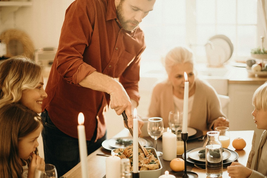 Easy Instant Pot Thanksgiving Appetizers a Man Carving a Turkey at the Table with Other People Sitting Around Watching