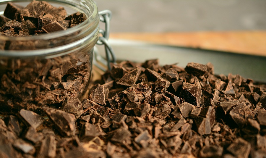 Crockpot Candy Recipes with Almond Bark Chocolate Chopped Up Next to a Jar Full of Chocolate Chunks