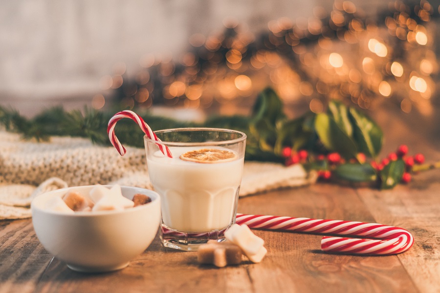 Crockpot Candy Recipes a Cup of Milk with a Candy Cane In It Next to a Small Bowl of Sweets on a Wooden Table