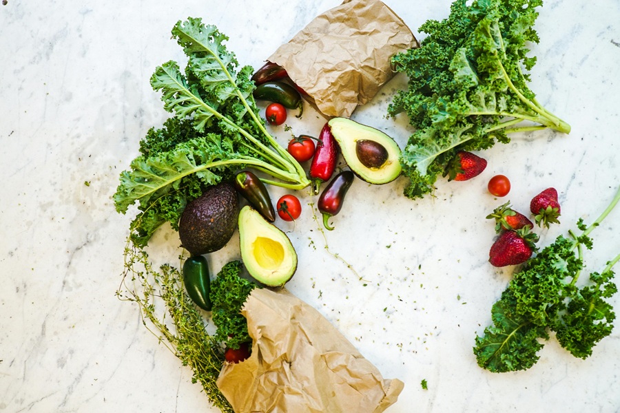 Healthy Instant Pot Family Dinners Two Paper Bags Spilled Over with Veggies and Fruits on a Marble Counter