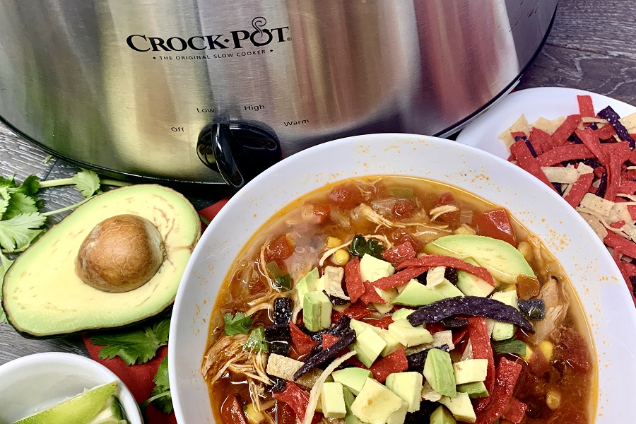 Crockpot Chicken Breast Recipes for Dinner Close Up of a Bowl of Taco Soup Next to a Crockpot and a Couple of Avocados
