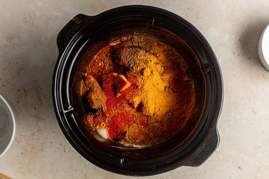 Crockpot Chicken Tikka Masala Recipe View of the Inside of a Crockpot Filled with Ingredients and Covered in Seasonings