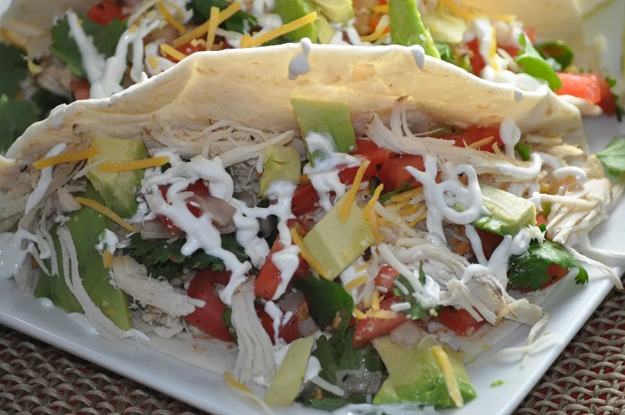Crockpot Chicken Breast Recipes for Dinner Close Up of Shredded Chicken Tacos with Sour Cream, Lettuce, and Avocado